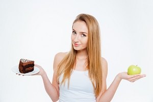 Attractive woman holding healthy and unhealthy food