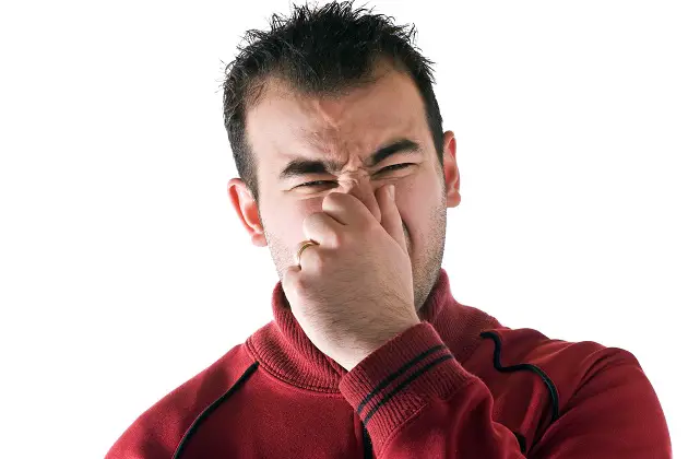 man holds or pinches his nose