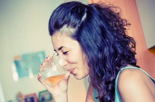 women drinking apple cider vinegar with water