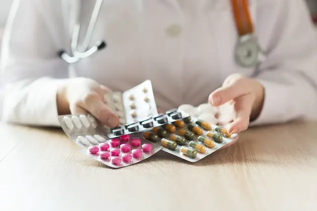 doctor’s hands holding pills