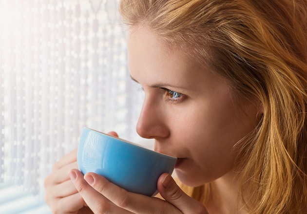 woman sipping coffee from her cup
