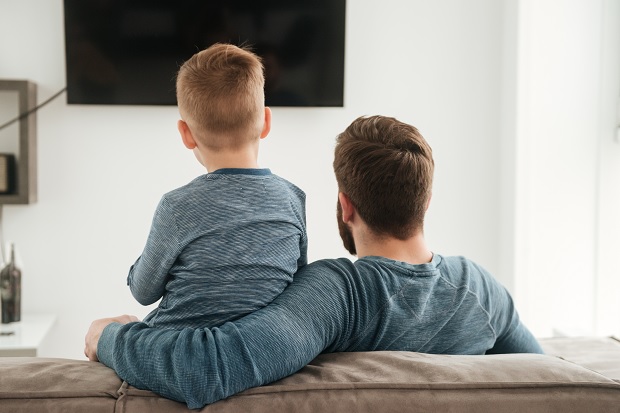 father and son in front of television